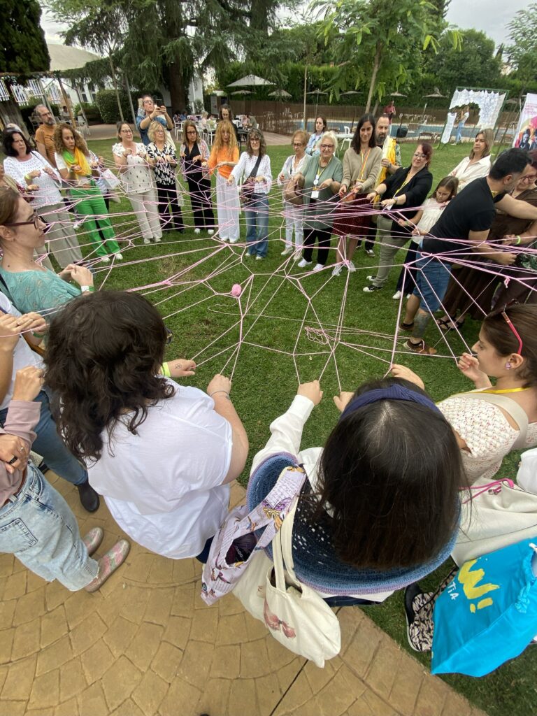 Grupo de personas creando una tela de araña con lana.
